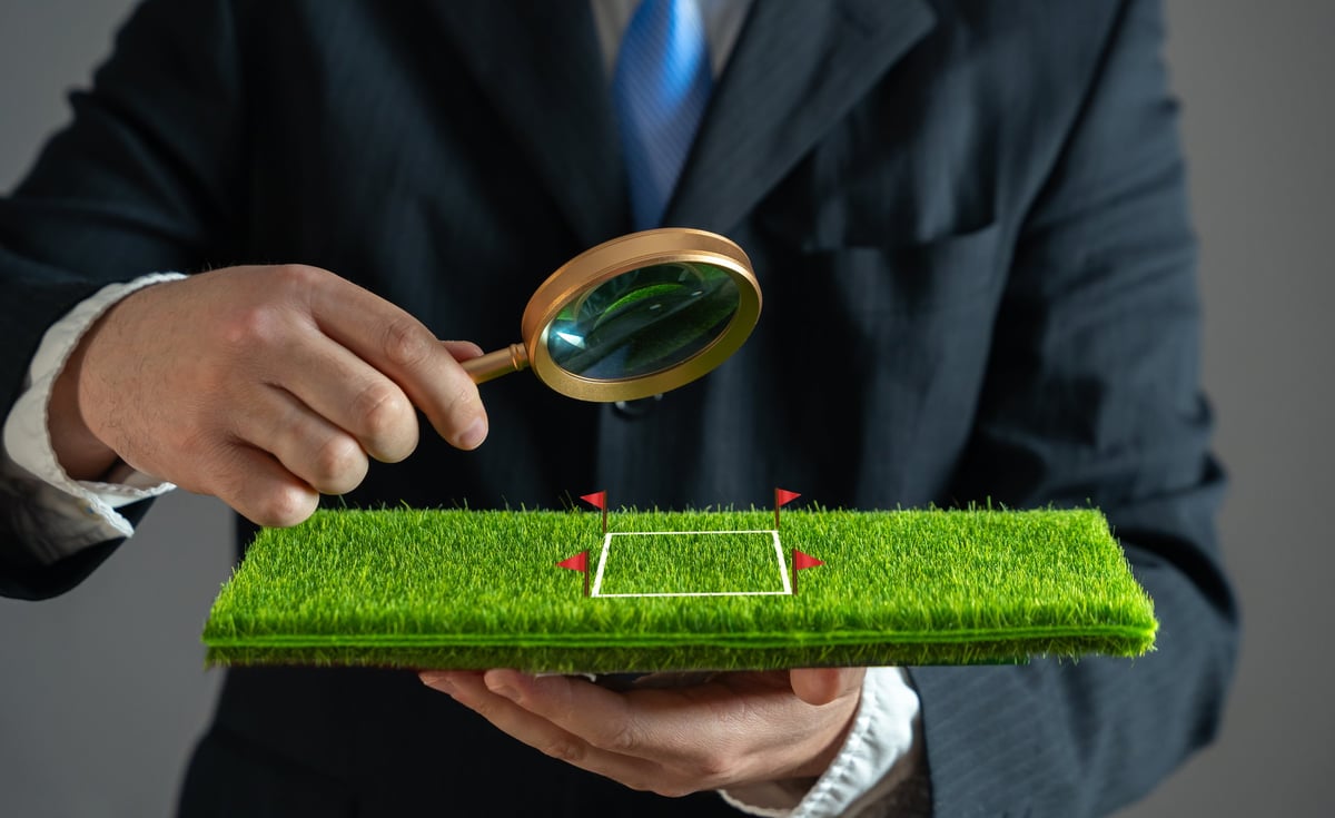 Businessman examining plot of land