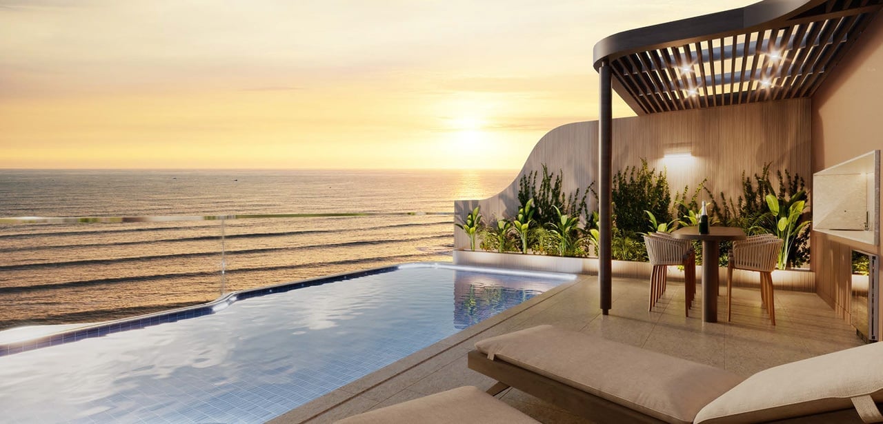 Luxurious infinity pool overlooking ocean at sunset with lounge chair, pergola, dining area, and coastal views
