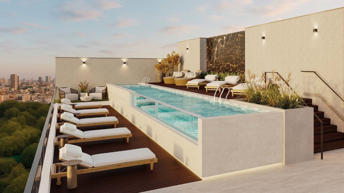Rooftop terrace with rectangular pool, lounge chairs, and city skyline view