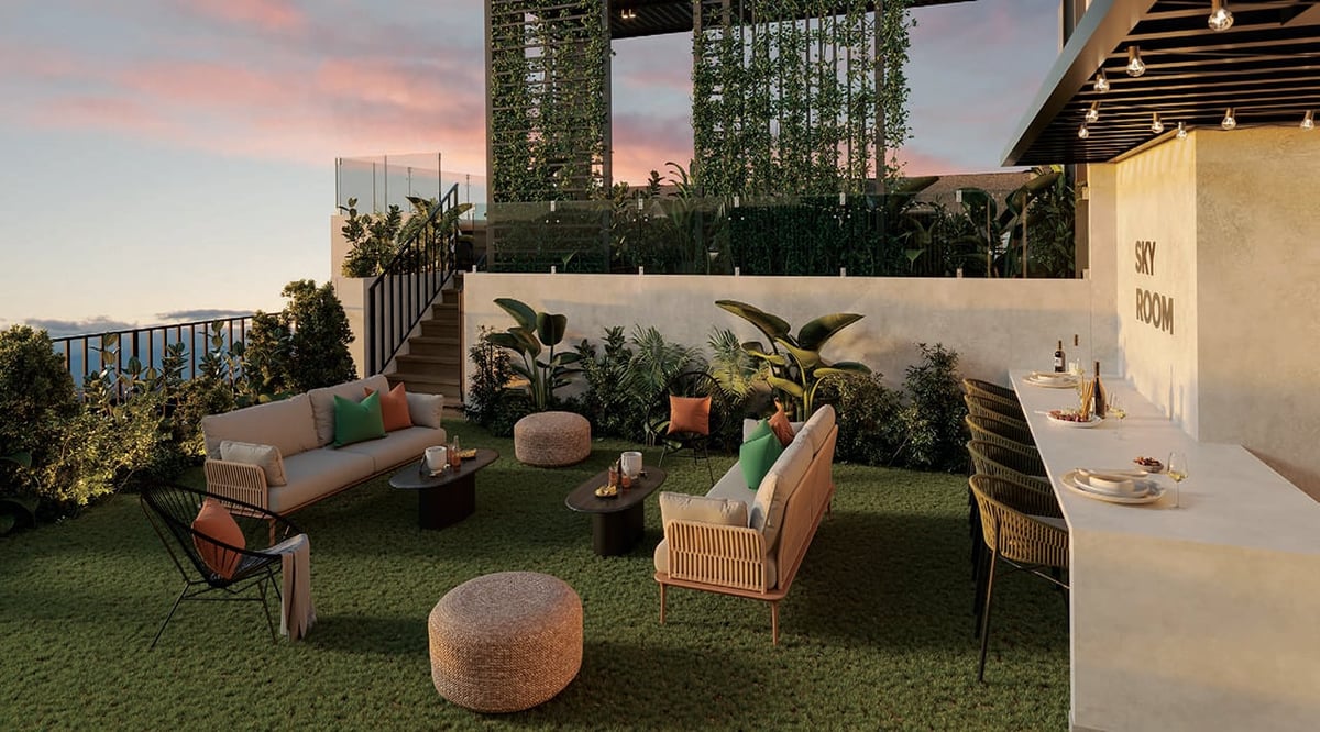 Modern rooftop terrace with lounge furniture, green artificial grass, plants, and city skyline at sunset