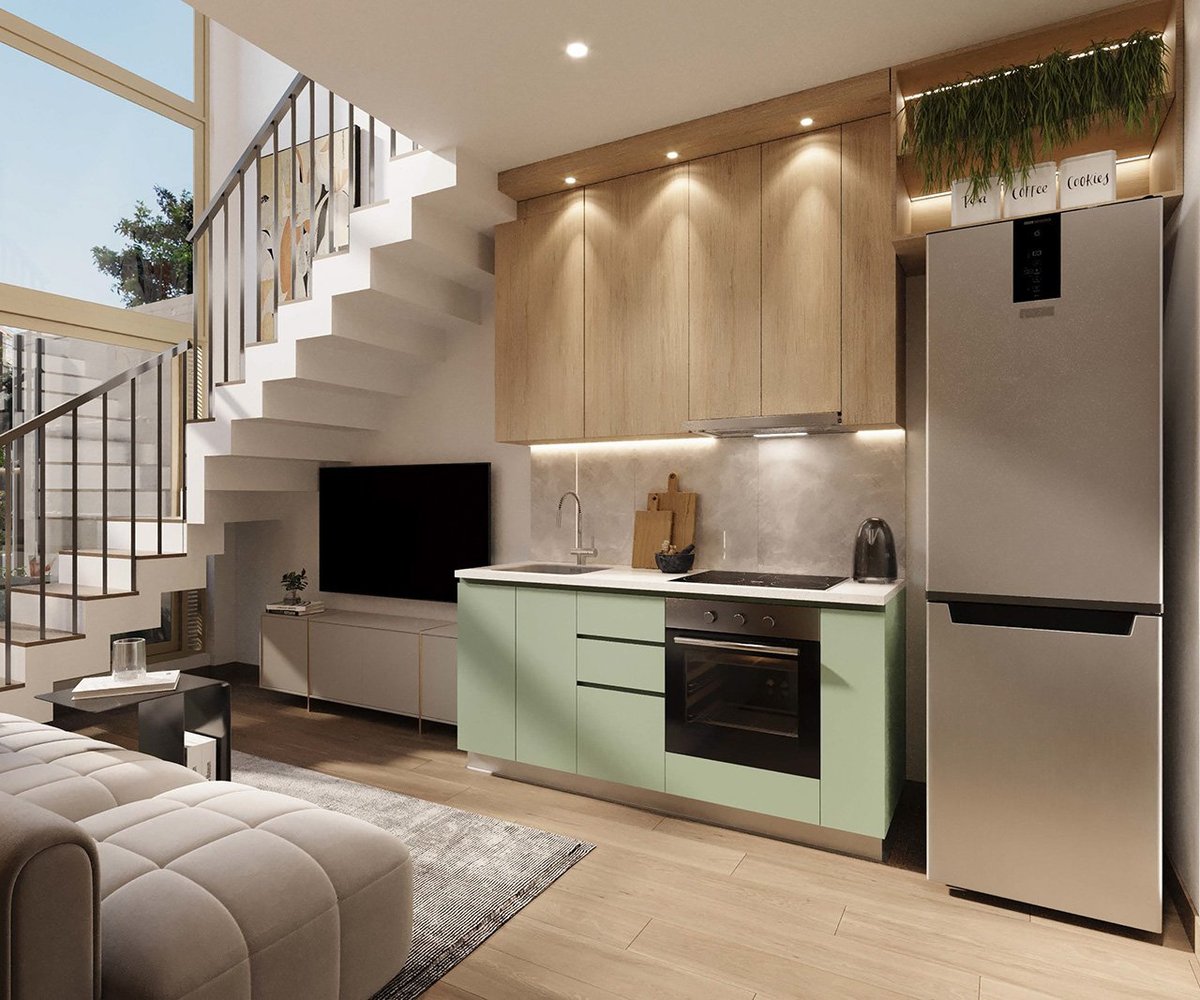 Modern open-plan kitchen and living area with light wood cabinetry, sage green kitchen island, stainless steel appliances, and floating staircase.