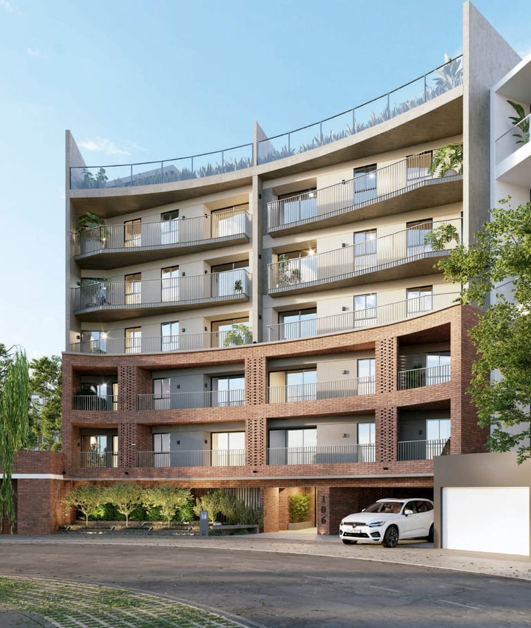 Modern multi-story residential building with brick and beige facade, multiple balconies, and covered parking with white vehicle