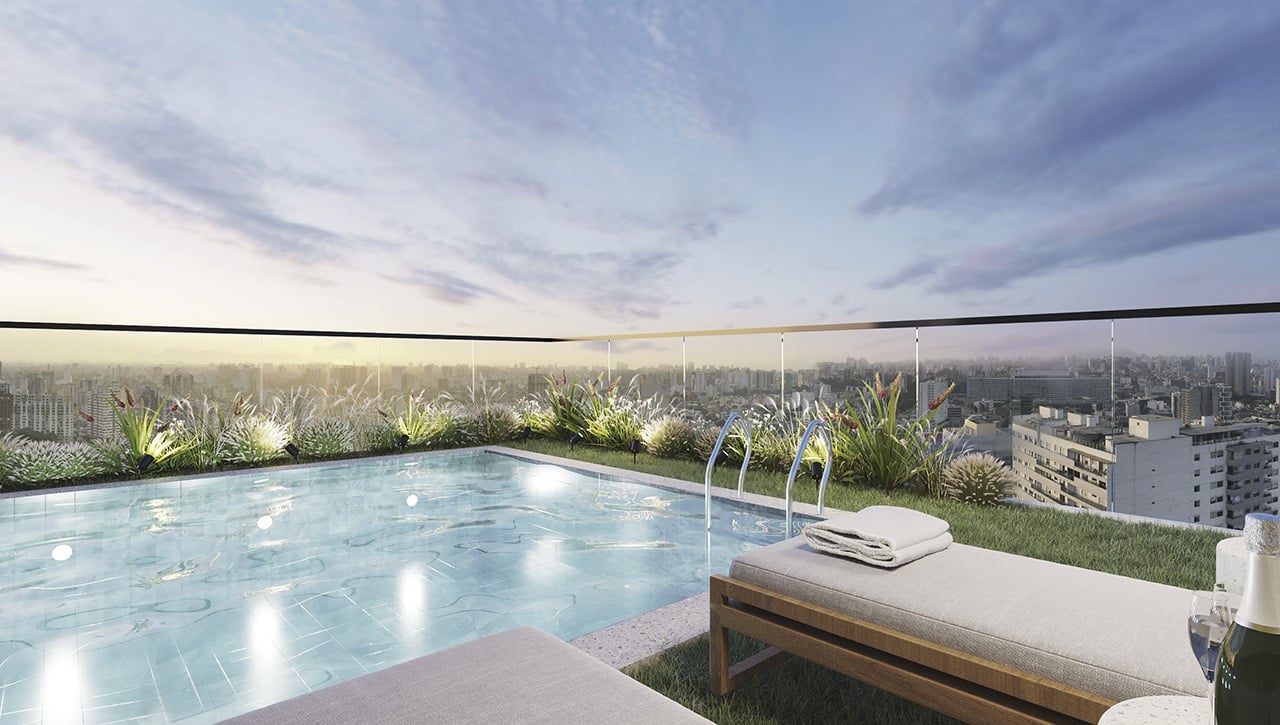 Rooftop infinity pool overlooking a cityscape at dusk with mountains in the distance