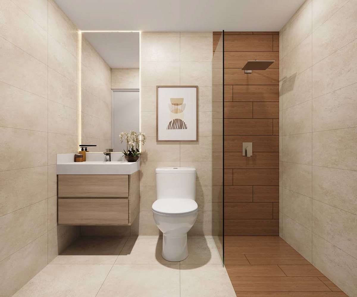 Modern bathroom interior with beige tile walls, wooden vanity, illuminated mirror, white toilet, and walk-in shower with brown tile accent wall
