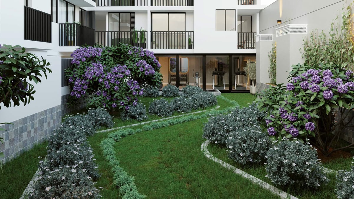 Modern courtyard with manicured green lawn, purple flowering bushes, white flowering plants, and white residential buildings with balconies