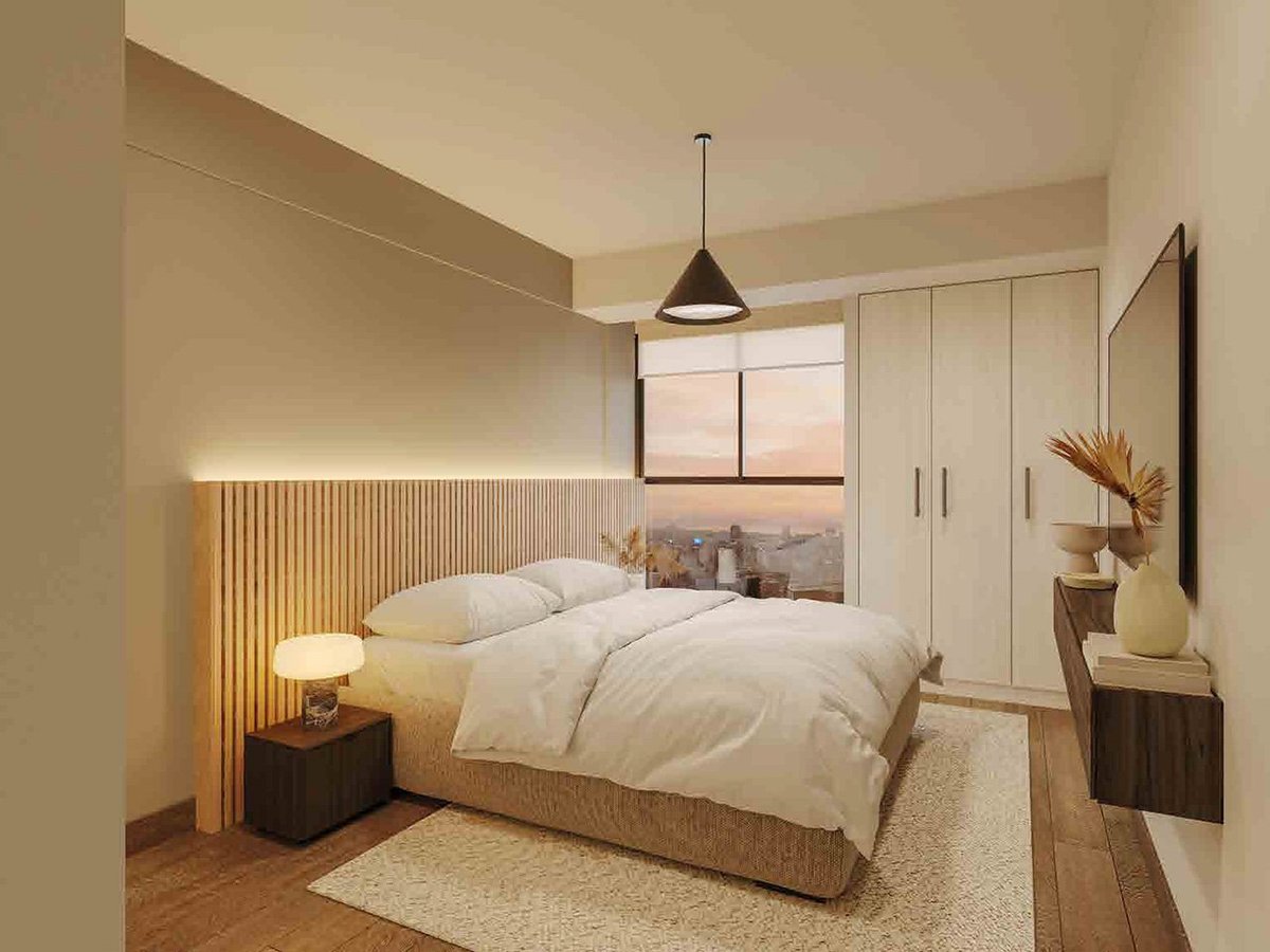 Modern bedroom with white bedding, wooden headboard with ambient lighting, pendant lamp, beige rug, and built-in wardrobe