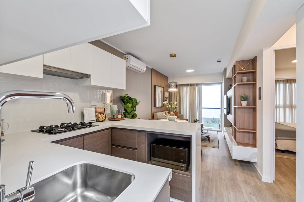 Modern kitchen with white upper cabinets, dark lower cabinets, gas cooktop, stainless steel appliances, and wood-look flooring.