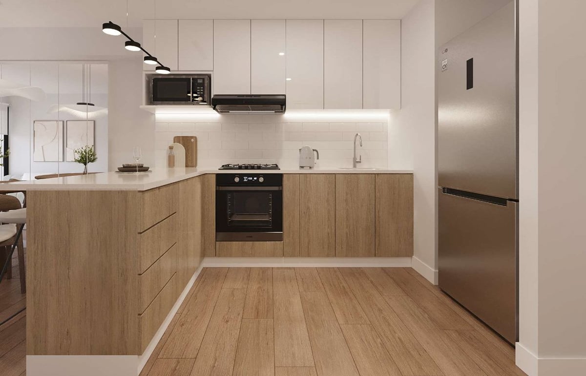 Modern kitchen with light wood cabinetry, white countertops, stainless steel appliances, and wooden flooring