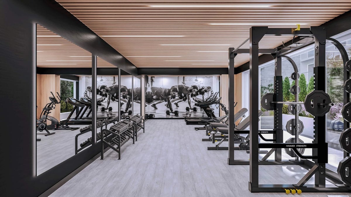 Modern gym interior with exercise equipment, large windows, and natural light from outdoor terrace
