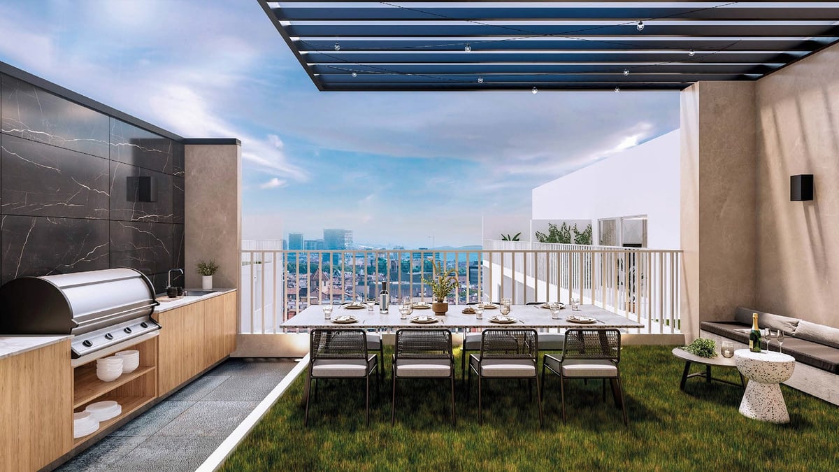 Modern rooftop terrace with outdoor kitchen, dining table, and city skyline view overlooking a metropolitan landscape.