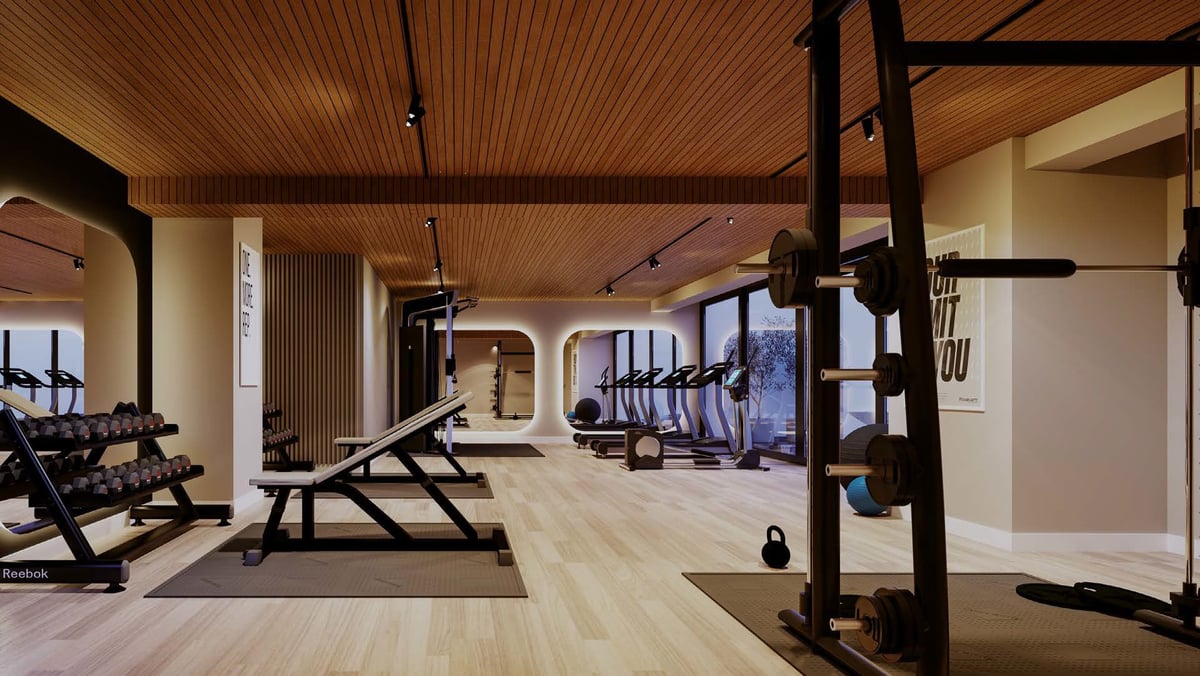 Modern gym interior with exercise equipment, wooden ceiling, and light wood flooring throughout the spacious facility.
