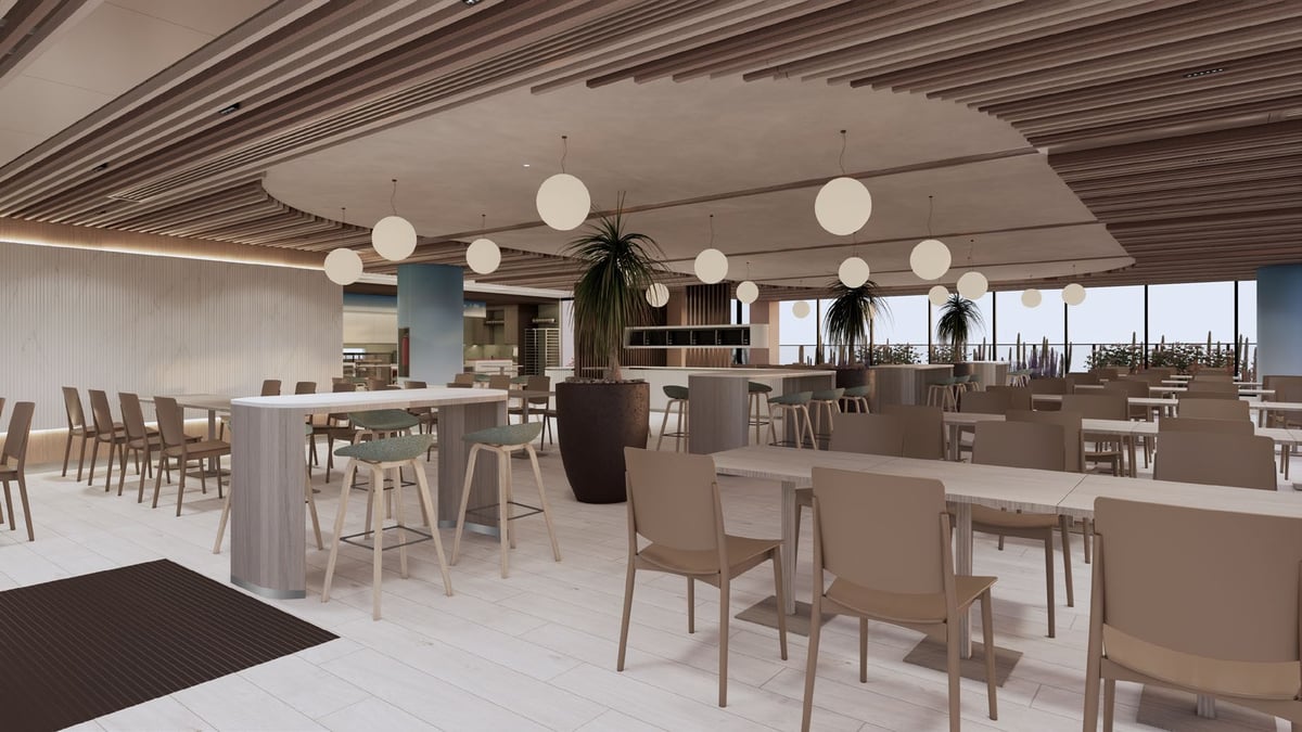 Modern office break room with round pendant lights, bar seating, tables, and floor-to-ceiling windows overlooking city skyline
