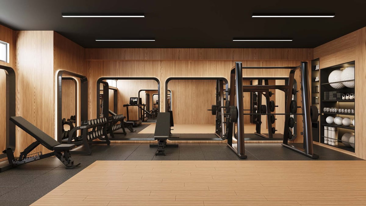Modern home gym with wooden walls, exercise machines, weight racks, and storage shelving with equipment