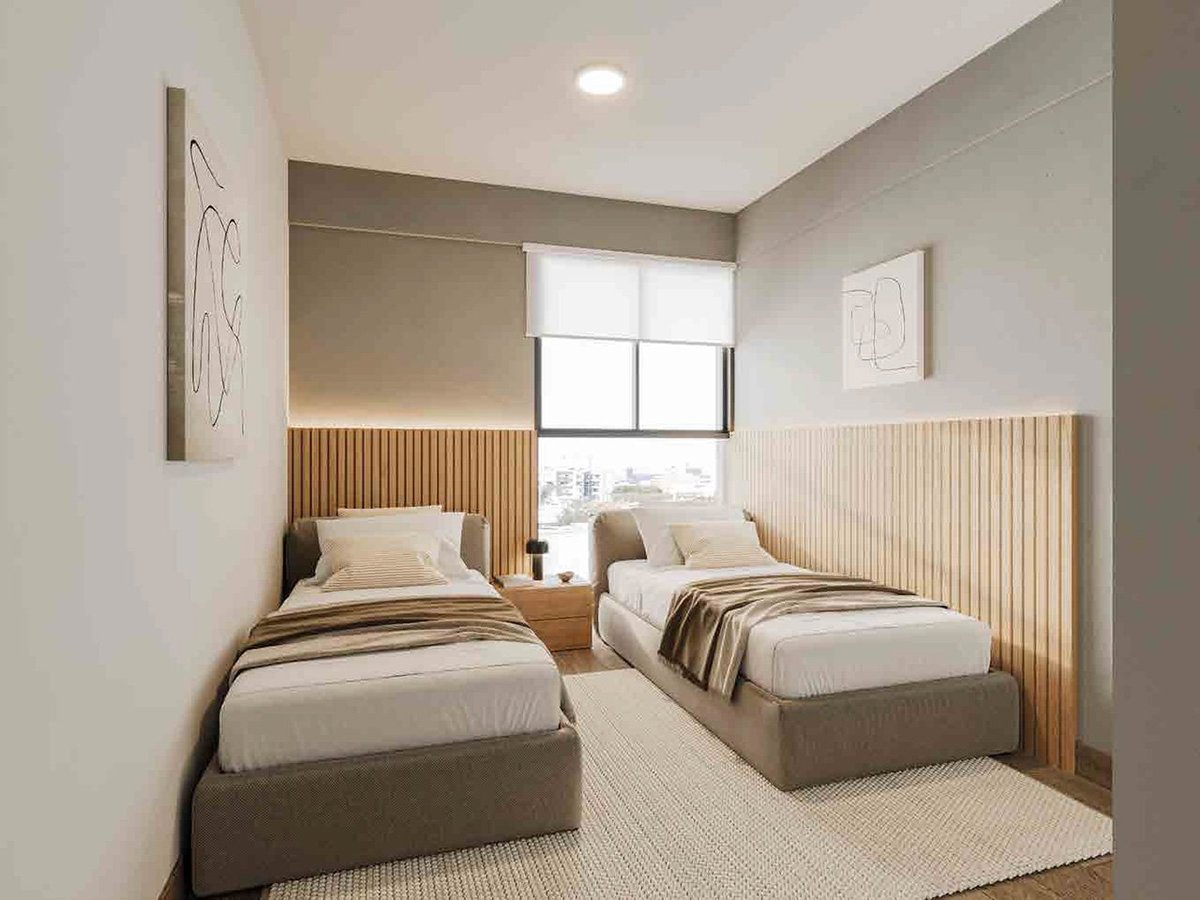 Modern bedroom with two twin beds with wood headboards, small window, and minimalist decor in neutral tones