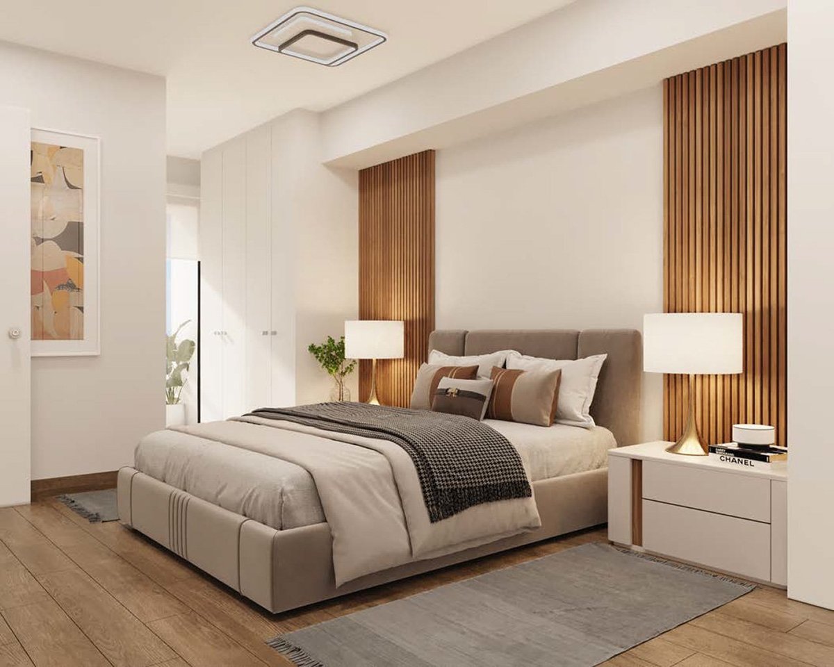 Modern bedroom interior with beige upholstered bed, wooden accent wall paneling, nightstands with lamps, and neutral color palette