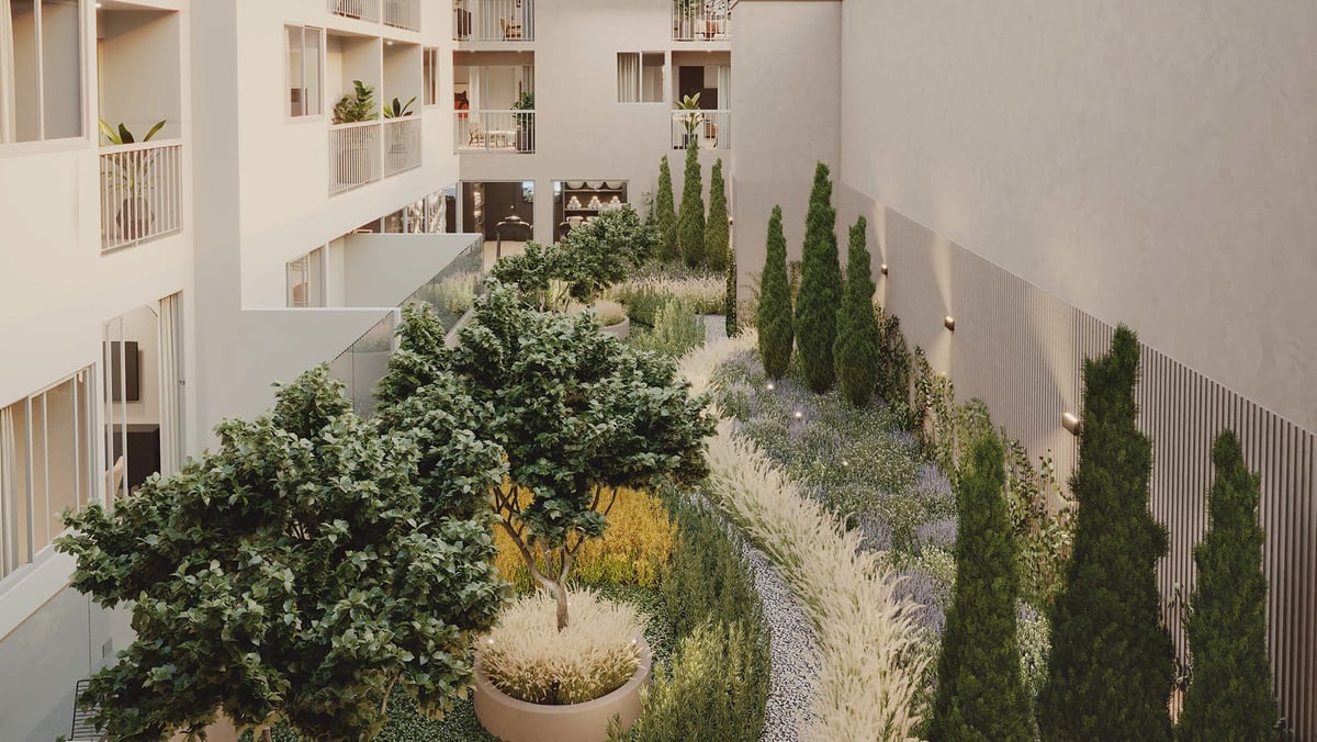 Aerial view of a modern courtyard with potted plants, cypress trees, and gravel pathways between white residential buildings