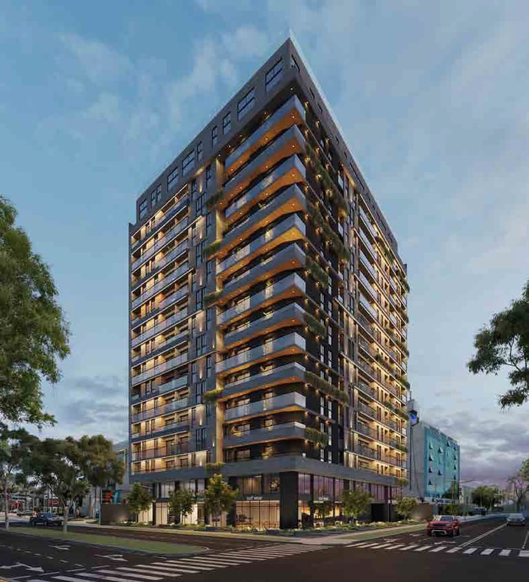 Modern multi-story residential building with illuminated balconies at dusk, surrounded by trees and street-level retail.