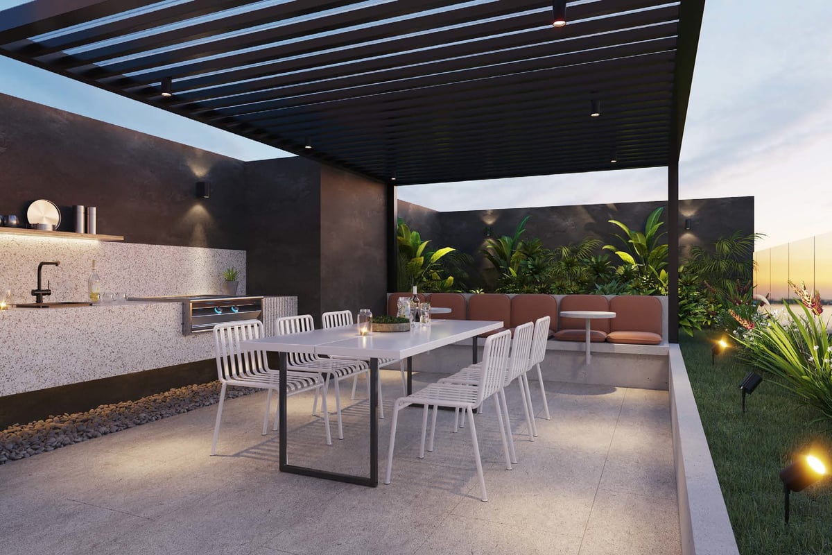 Modern rooftop terrace with outdoor dining area, kitchen, white chairs, and contemporary architecture at dusk