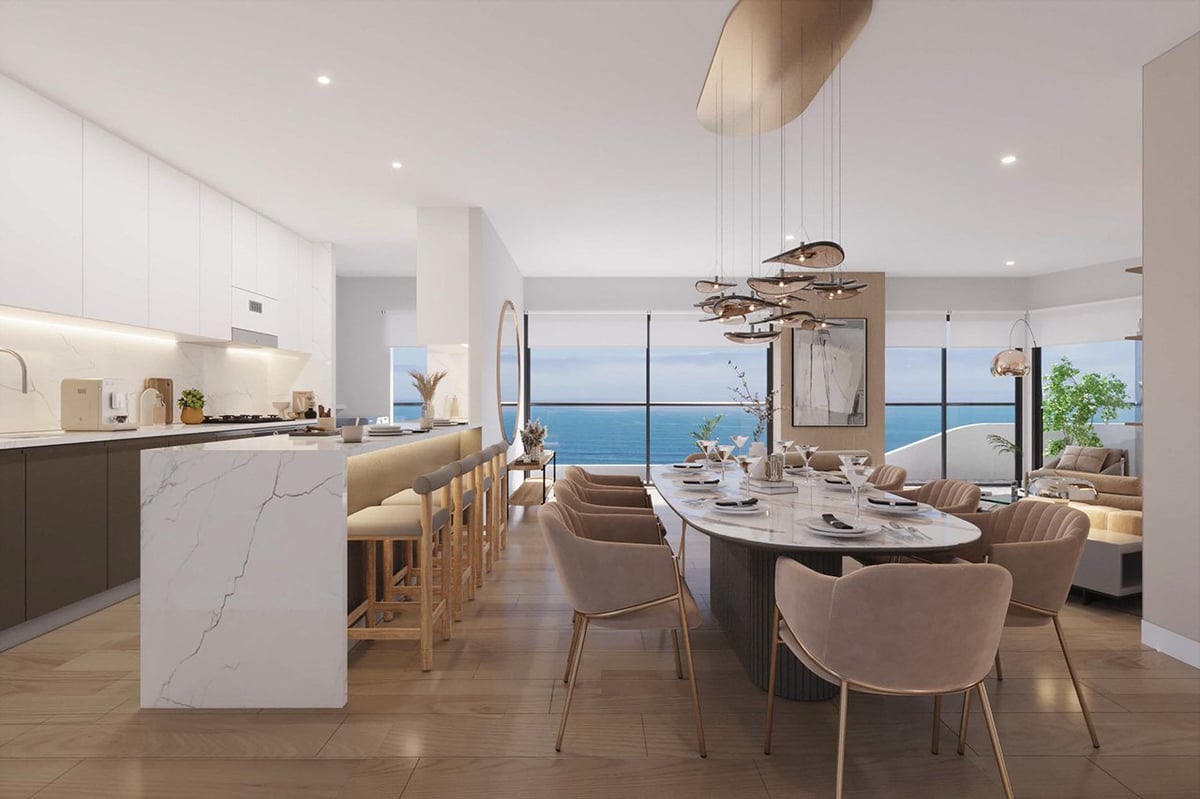 Modern luxury apartment interior with open kitchen, dining area, and ocean views through large windows