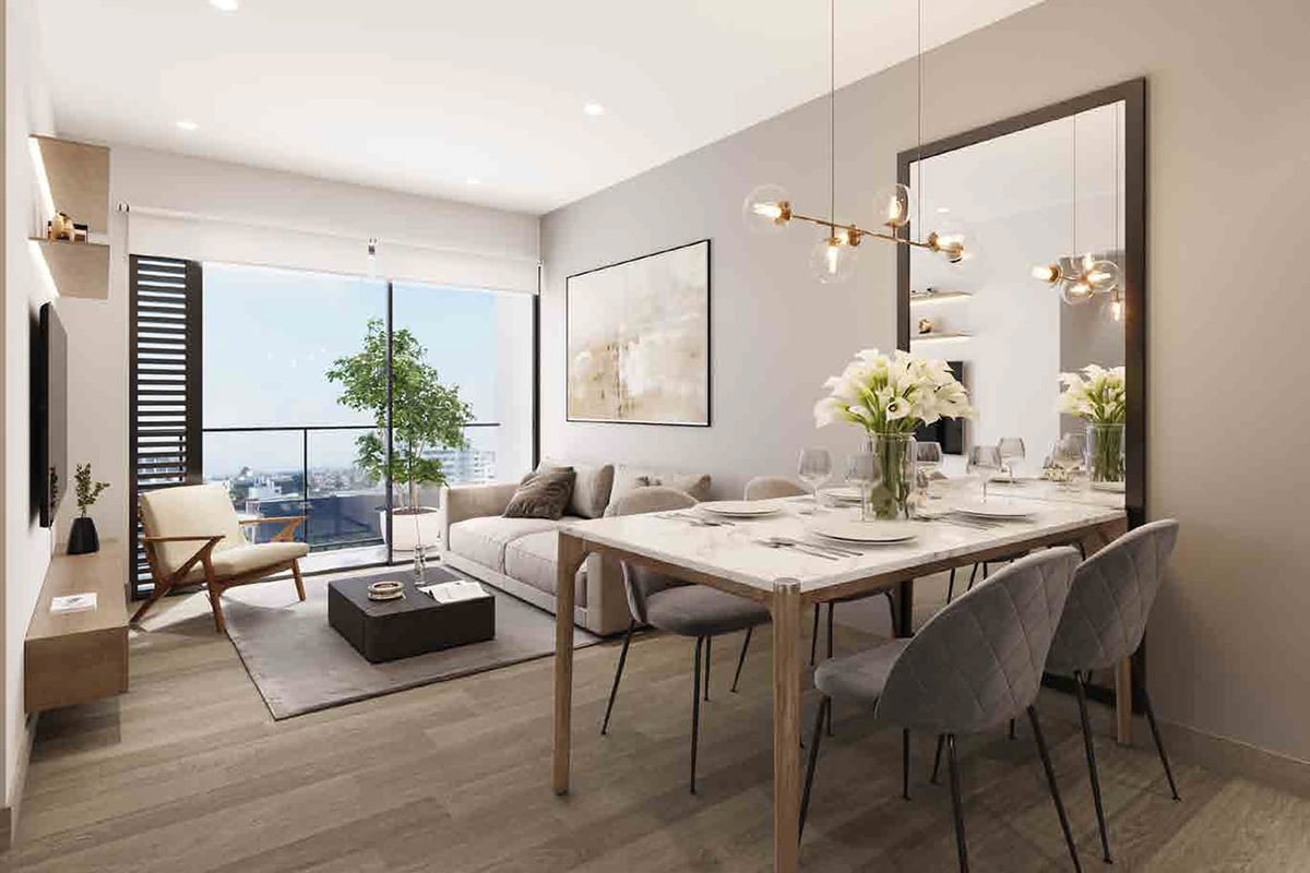 Modern studio apartment with open floor plan featuring dining table, living area, floor-to-ceiling windows overlooking cityscape, and contemporary furnishings in neutral tones