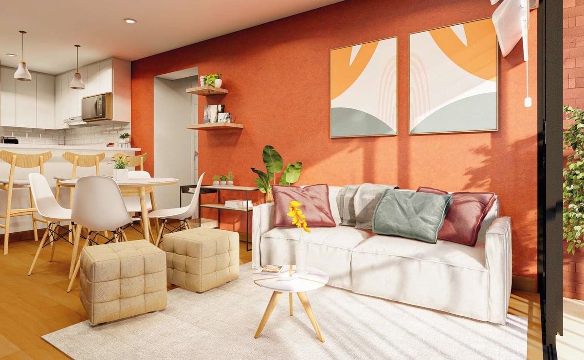 Modern open-concept living room with cream sofa, orange accent wall, white abstract art, dining area with wooden table, and potted plants.