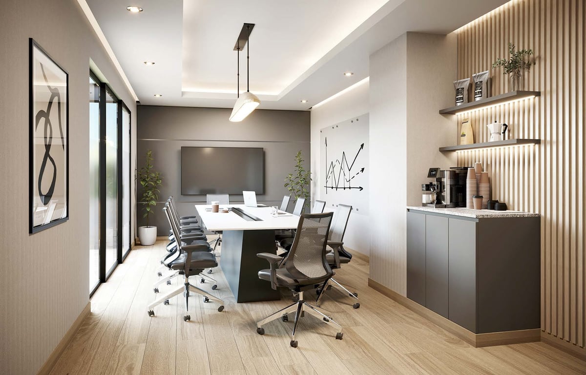 Modern office conference room with round white table, ergonomic chairs, wall-mounted TV, wooden flooring, and shelving units.