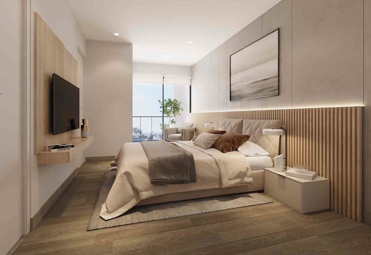 Modern bedroom with beige bedding, wooden accent wall, wall-mounted TV, and city views from large window