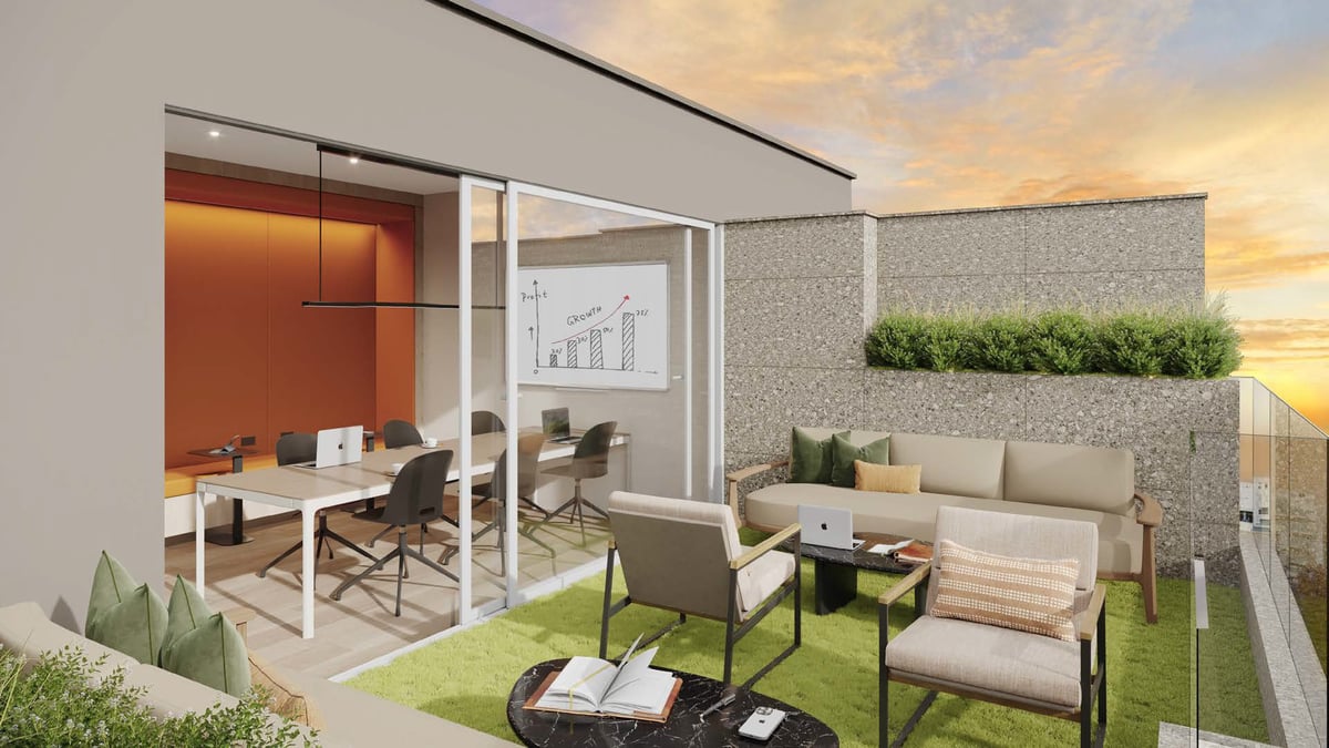 Modern office rooftop terrace with furnished seating area, artificial grass, and glass-walled workspace at sunset