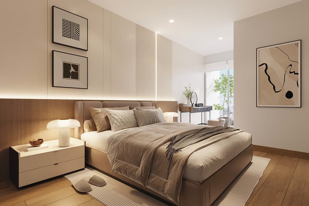 Modern bedroom with large bed, white nightstands with lamps, wooden flooring, neutral tones, and wall art