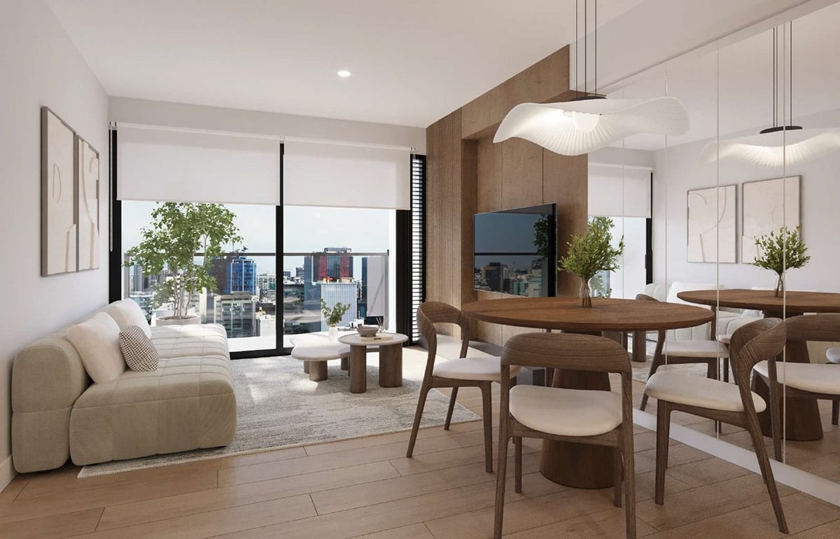 Modern apartment interior with curved beige sofa, wooden dining table, TV wall, and floor-to-ceiling windows overlooking cityscape