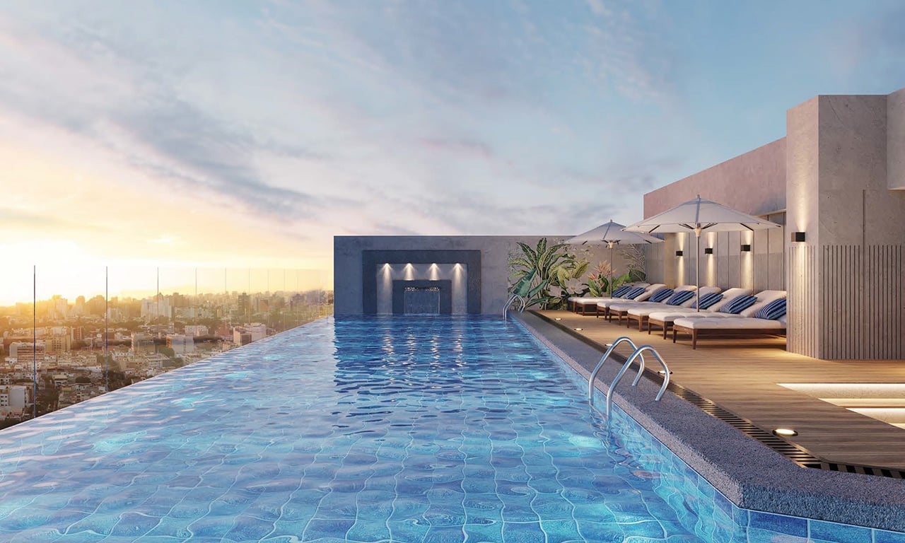 Rooftop infinity pool with modern architecture overlooking a cityscape at sunset