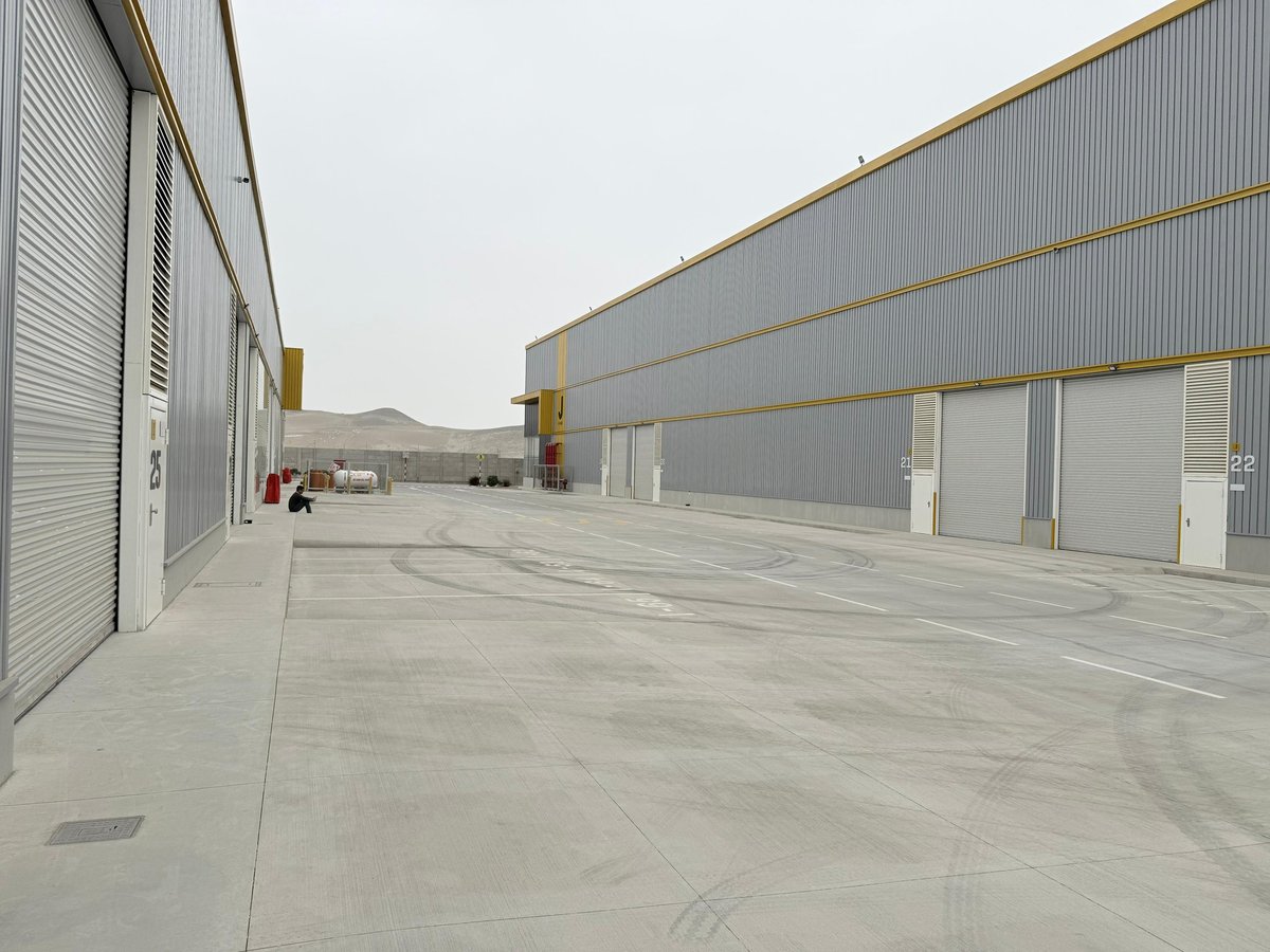 Empty industrial warehouse loading dock with metal buildings and concrete pavement