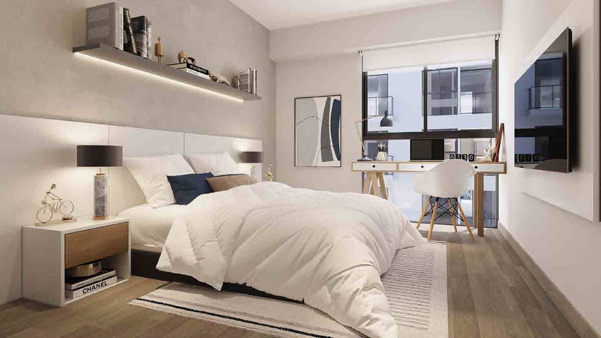 Modern bedroom with white bed, wooden nightstands, floating shelf, desk area, and large window with city view