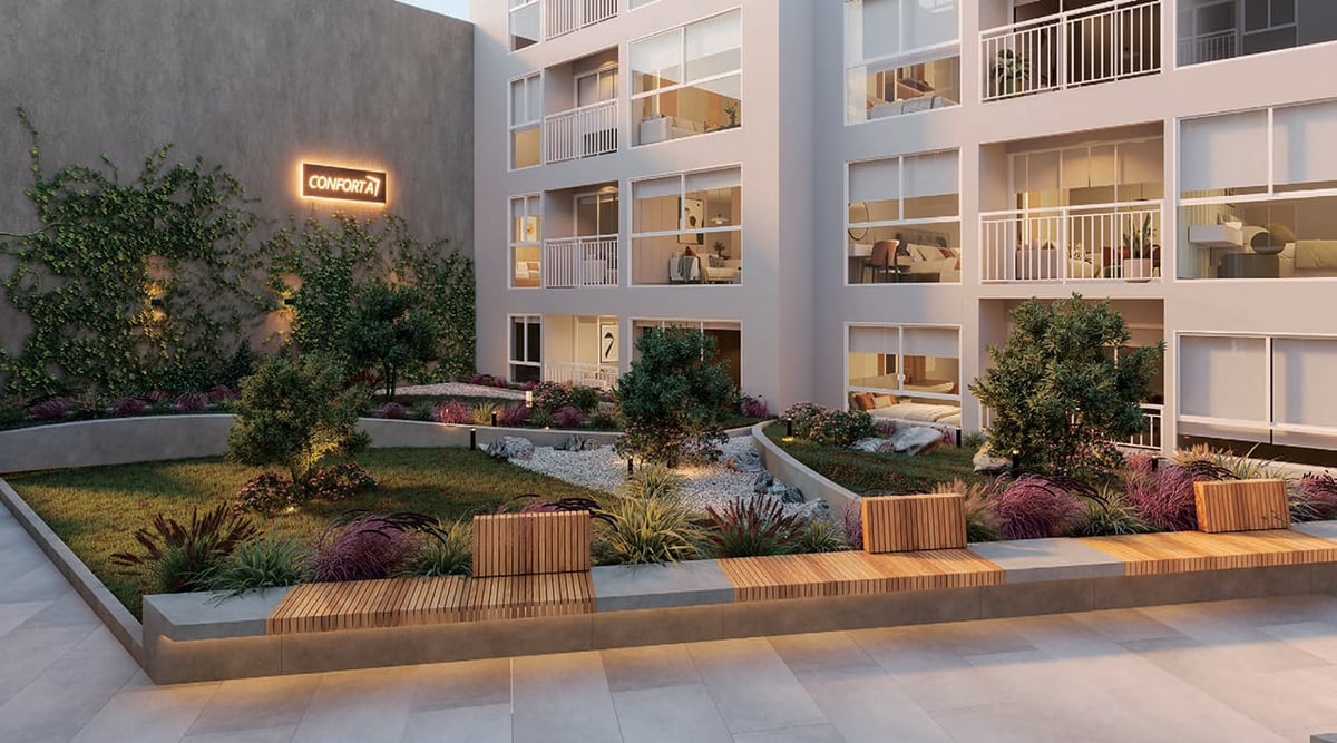 Modern residential courtyard with landscaped garden, seating areas, and apartment buildings at dusk