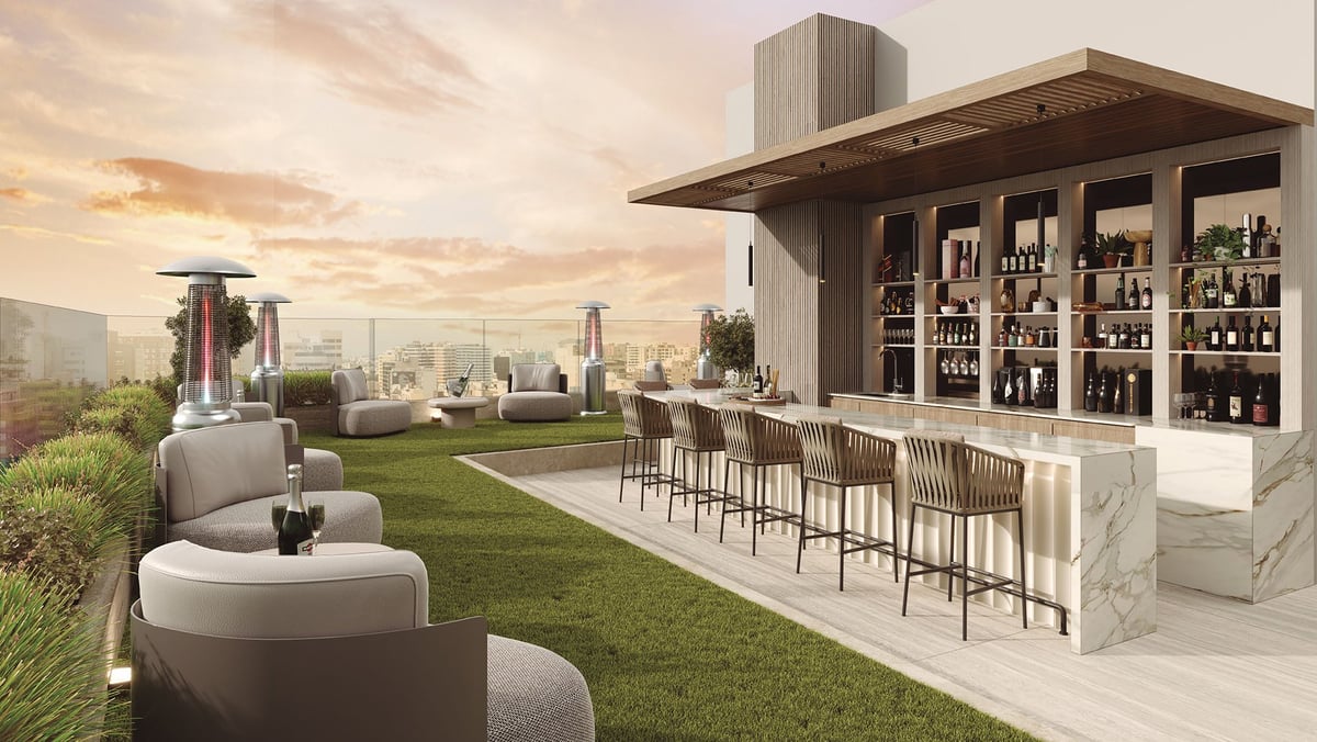 Rooftop bar and lounge with modern seating, outdoor heaters, and city skyline view at sunset