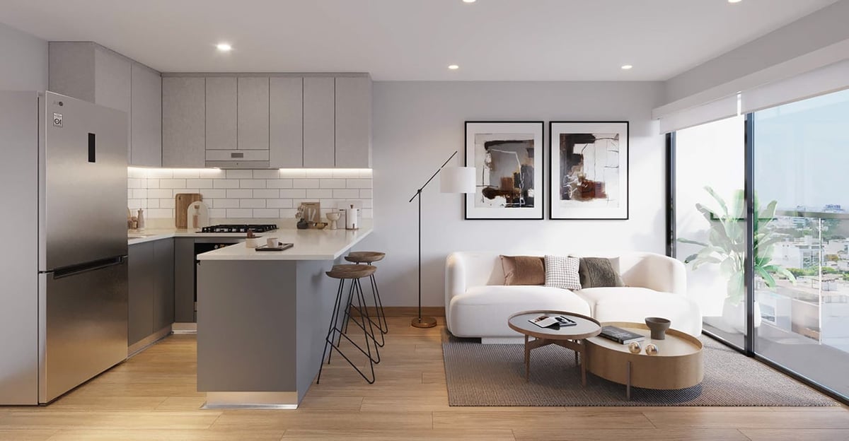 Modern open-concept apartment with gray kitchen island, stainless steel appliances, and cream-colored seating area with large windows overlooking city views